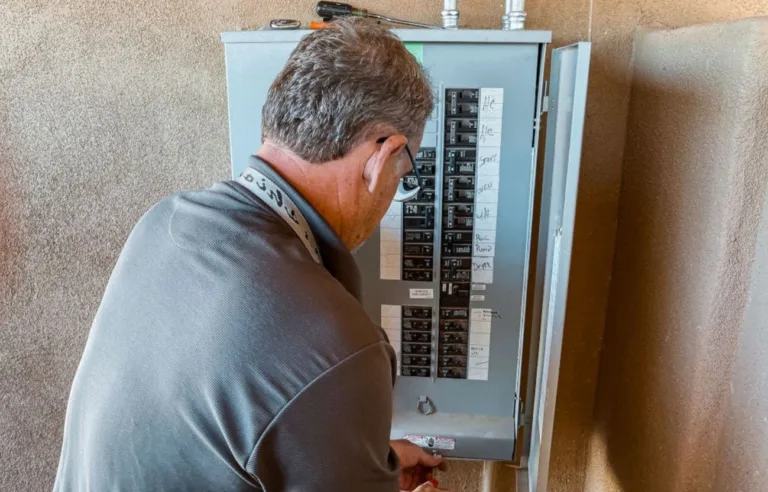 Propietario revisando el cuadro eléctrico de su vivienda para comprobar que cumple con el REBT